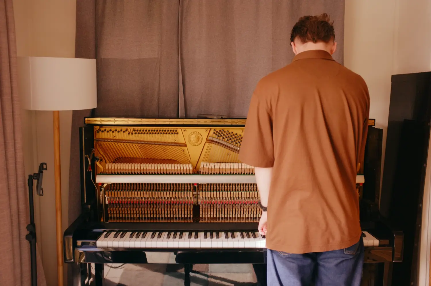 Reuben working at an upright piano with its action exposed
